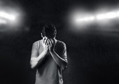 A man with his head in his hands looking down, recognizing a traumatic brain injury