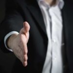 A man with his hand extended to shake someone else's hand. You can shake someones hand after hiring them for a job, but can you be held negligent?