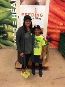 KFB Law volunteer Kirina and her son pose at Feeding Tampa Bay