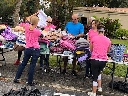 kinney, fernandez & boire community action program volunteers sort clothes at thanksgiving event