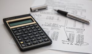 Calculadora y bolígrafo sobre un montón de documentos de seguro