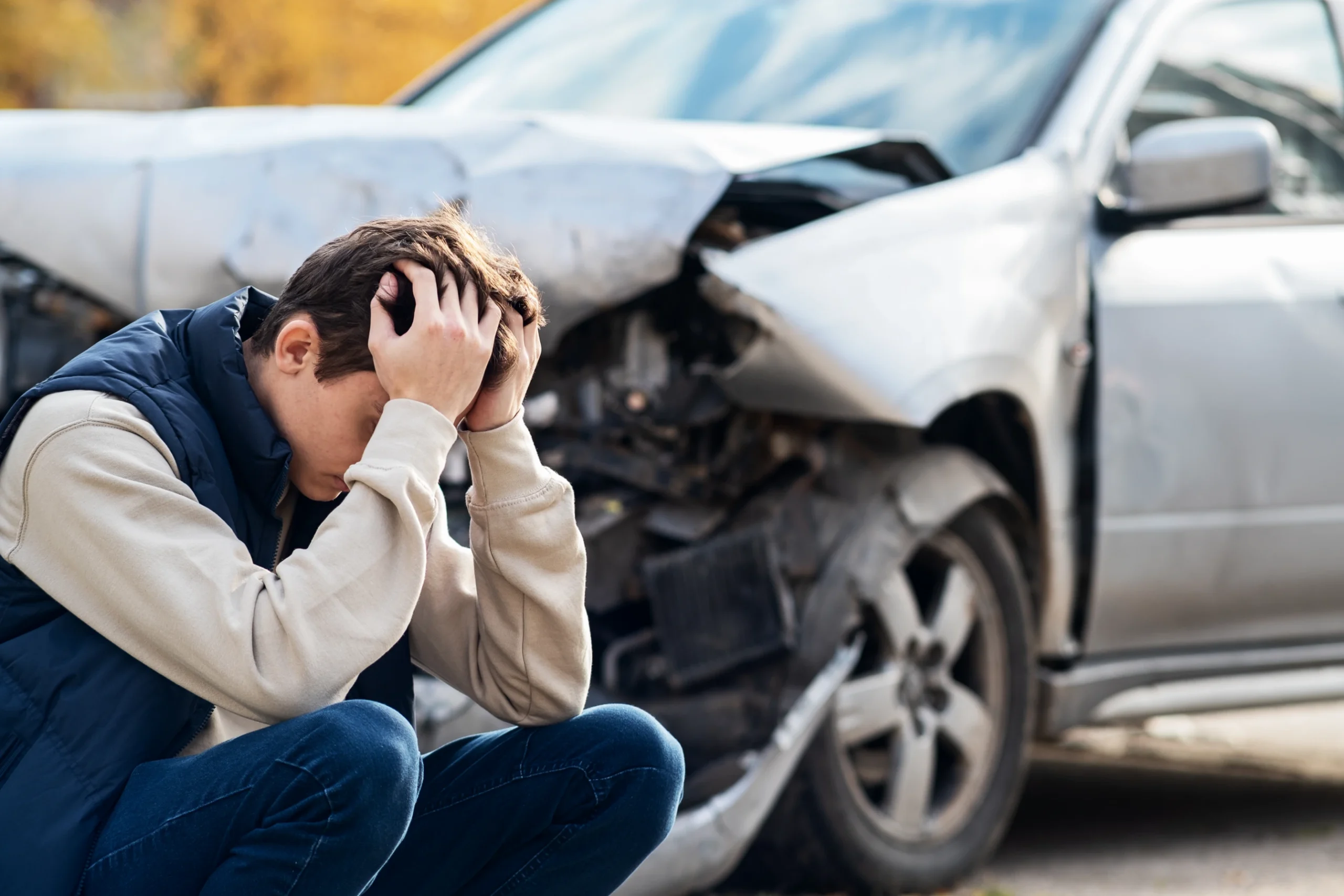 man sits by wrecked car needs motor vehicle defects lawyer in tampa fl